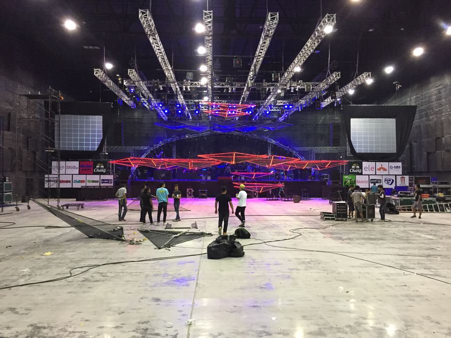Arena floor during load-in, lighting truss overhead