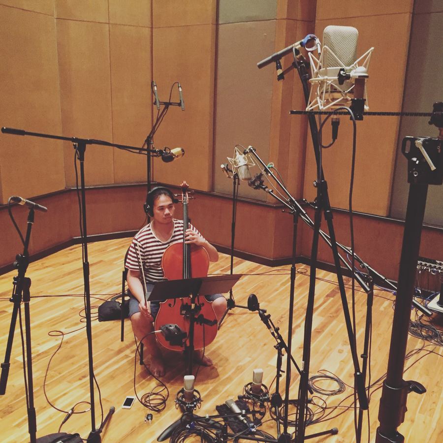 Cellist ringed by microphones in the live room