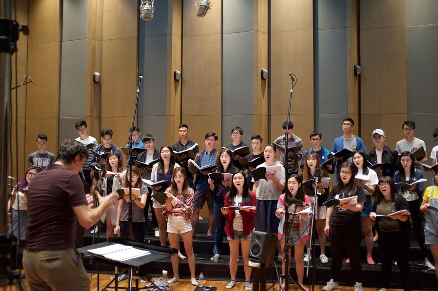 Large choir standing in rows with a conductor
