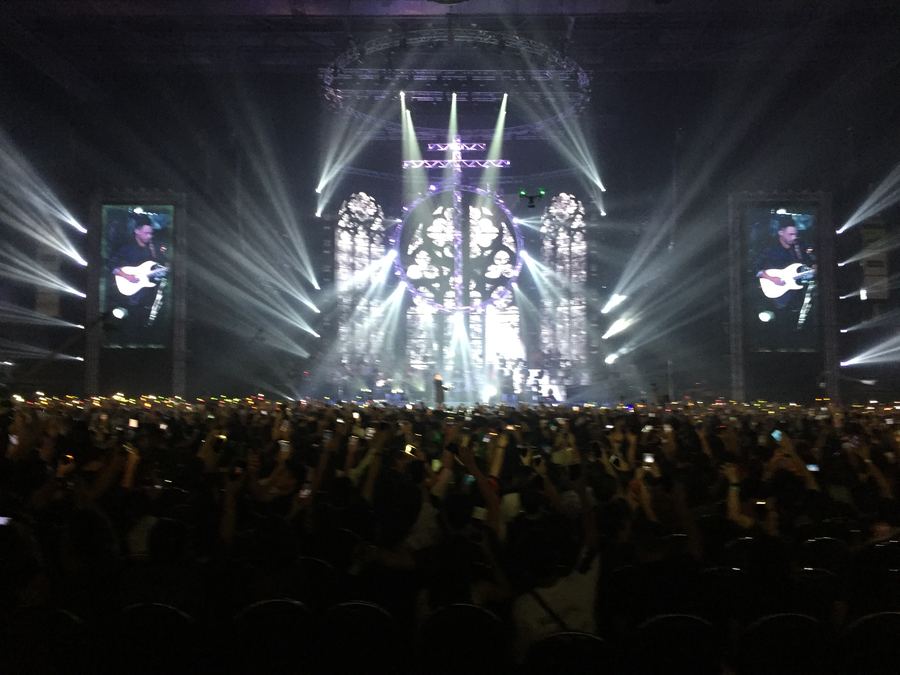 Concert stage with light beams over a crowd