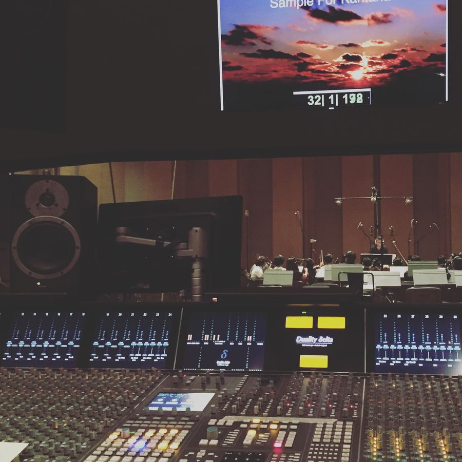 Console in the foreground, picture and timecode on screen above the orchestra