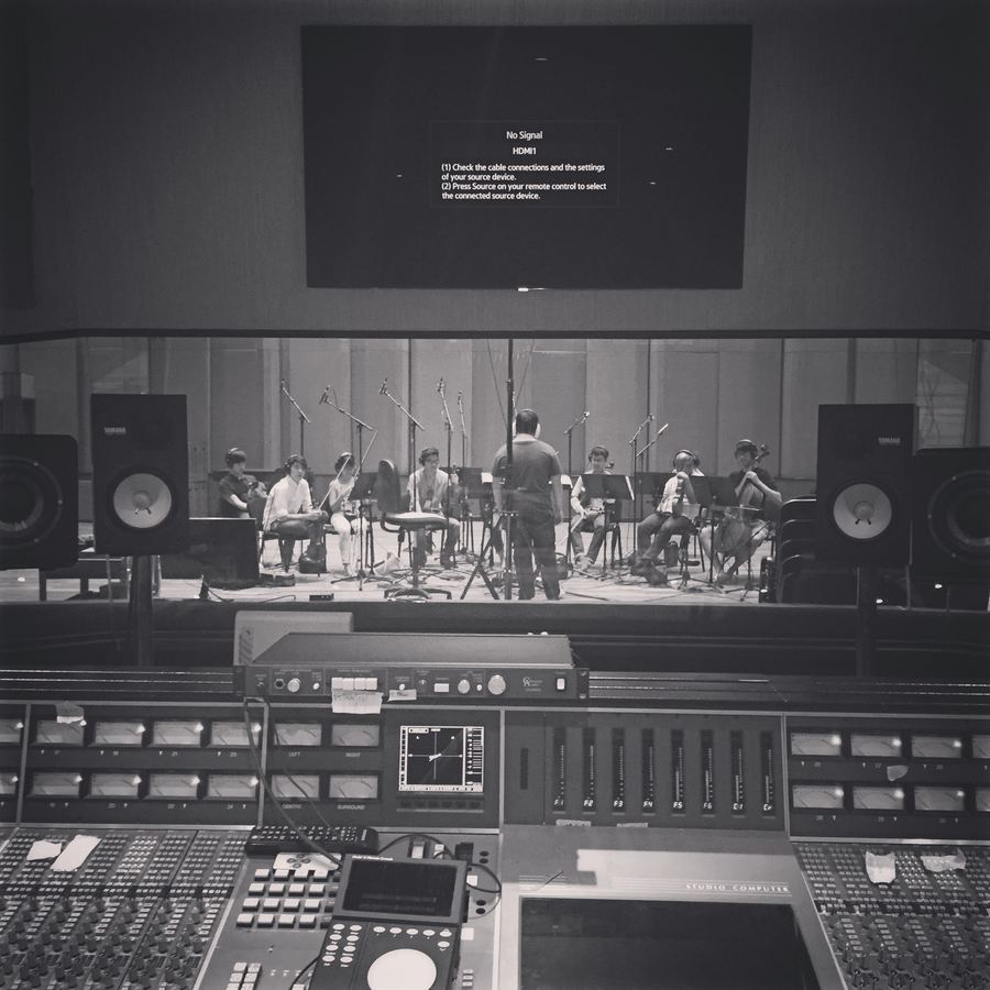 Ensemble seen through the control-room glass, console in the foreground