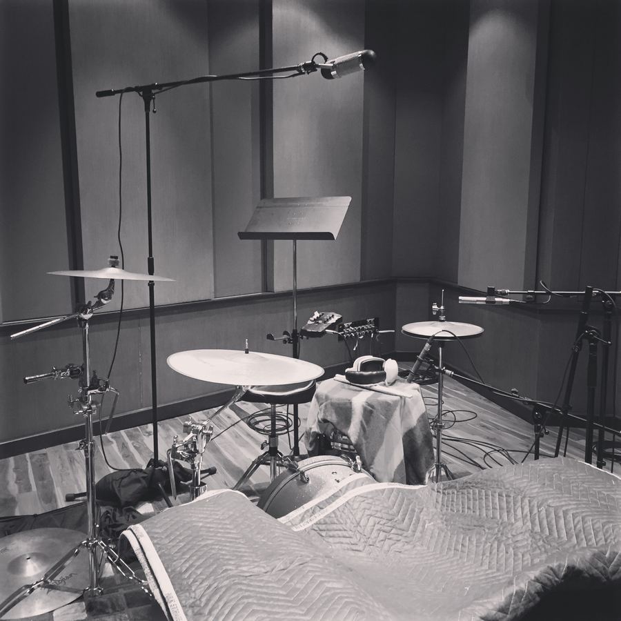 Drum kit and cymbals set up with microphones in a quiet room