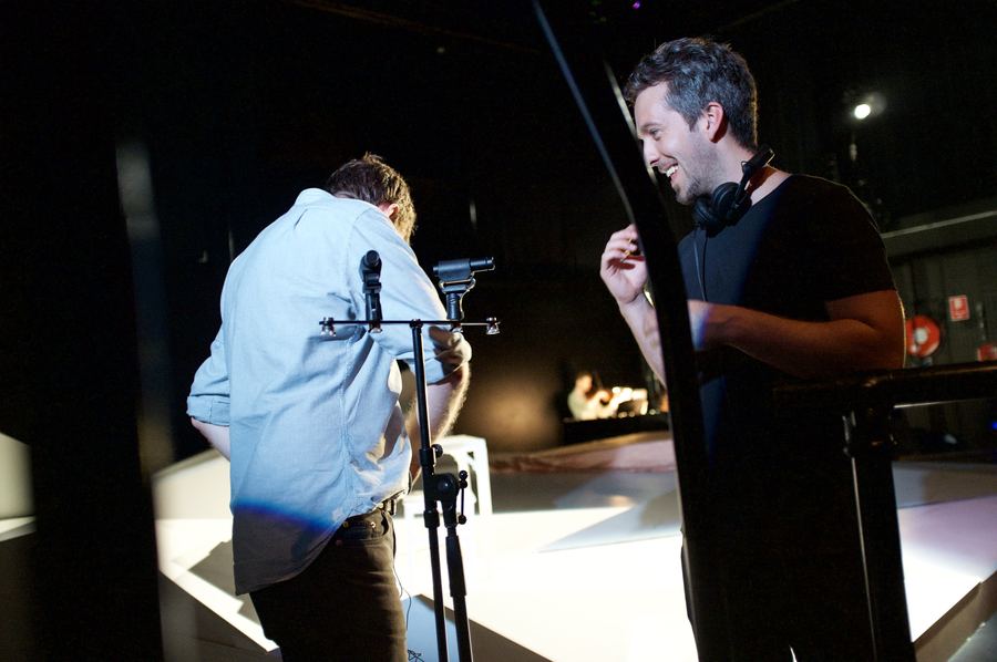 Two engineers talking between takes in a darkened live room