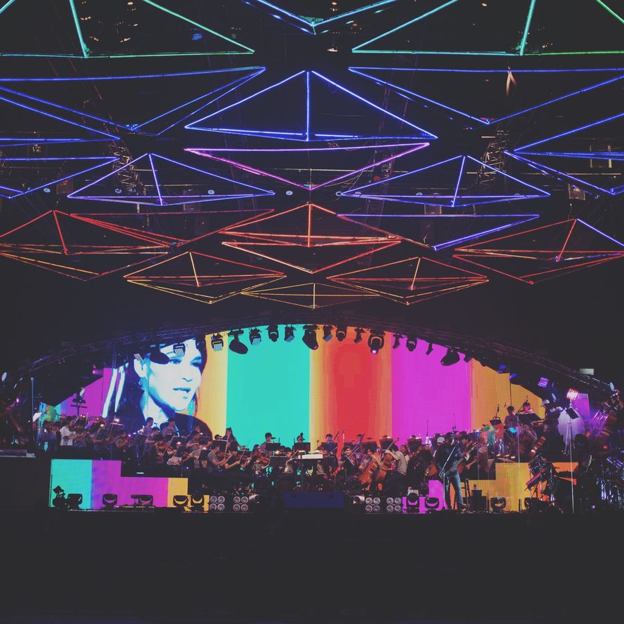 Orchestra on stage under a large lighting rig