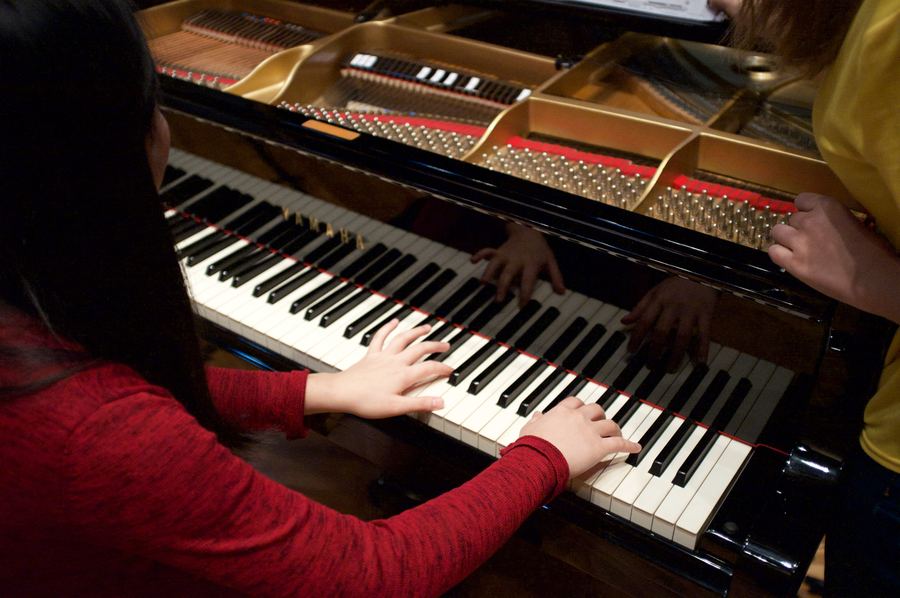 Pianist's hands on the keys of a grand piano