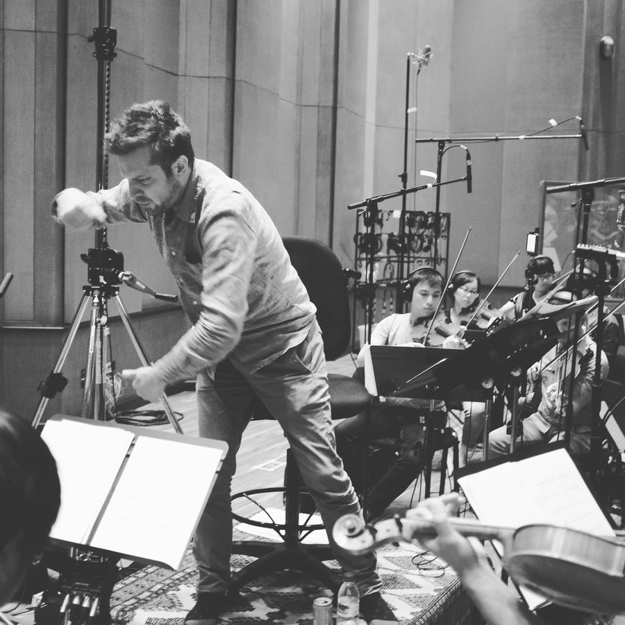Engineer adjusting a microphone stand among string players