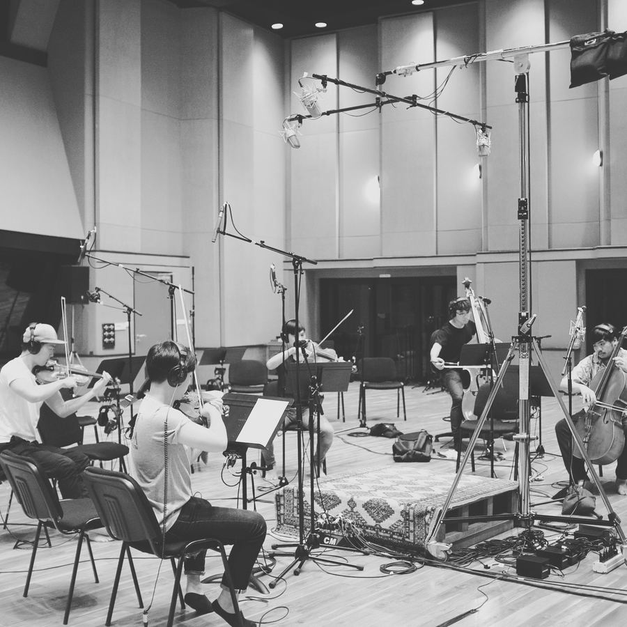 String players under a tree of microphones