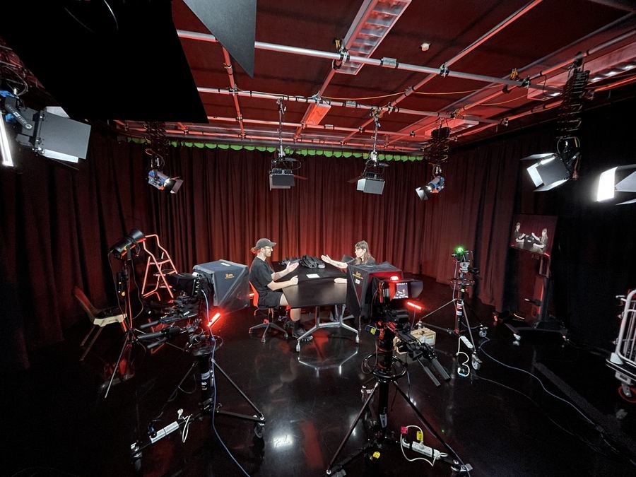 Multi-camera studio with a lighting grid and a two-person set